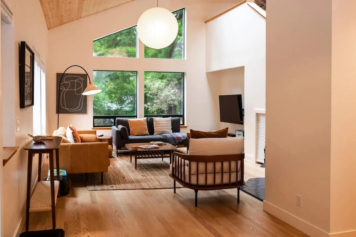 A sunlit living room among the trees at The Wild Kindness in Sea Ranch